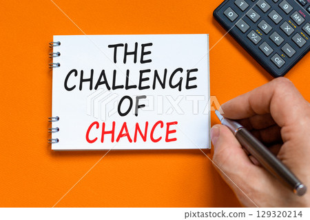 The challenge of chance symbol. Concept words phrase The challenge of chance on beautiful white note. Calculator. Beautiful orange background. Business The challenge of chance concept. Copy space. 129320214