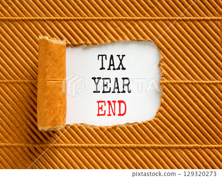 Tax year end symbol. Concept words Tax year end on beautiful white paper. Beautiful brown table brown background. Business tax year end concept. Copy space. Tax year end symbol. Concept words Tax year end on beautiful white paper. Beautiful brown table brown background. Business tax year end concept. Copy space. 129320273