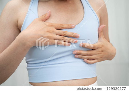 Asian woman self touching check lump or Breast cancer, Breast Self Exam. 129320277