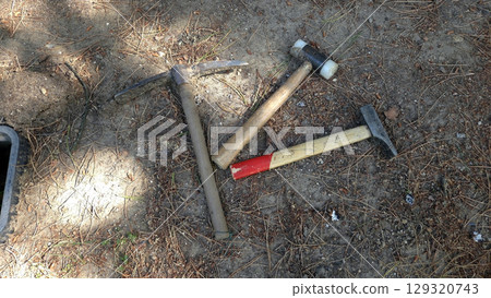 Outdoor hand tools on forest floor for camping or construction 129320743