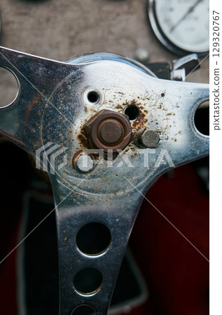 Close up of a car's steering wheel with a bolt missing Close up of a car's steering wheel with a bolt missing 129320767