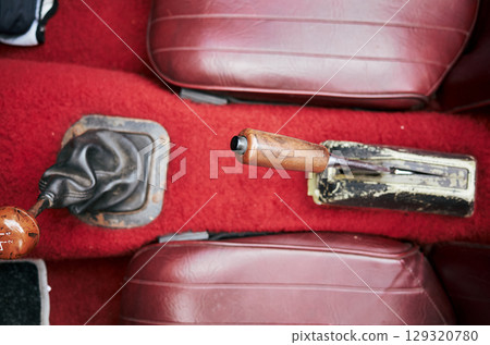 Car's gear shift is shown with a leather cover and a wooden knob Car's gear shift is shown with a leather cover and a wooden knob 129320780