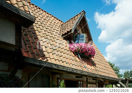 House with a red roof and a window with a flower basket House with a red roof and a window with a flower basket 129321026