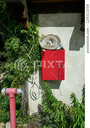 Red fire hydrant is next to a green bush Red fire hydrant is next to a green bush 129321056