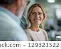 Smiling woman with glasses in a meeting or consultation displaying professional confidence 129321522