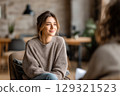 Smiling young woman in therapy session, seeking mental wellness support in a modern office 129321523