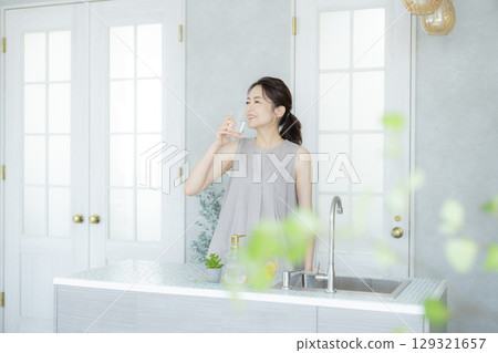 中年婦女在廚房喝水 129321657