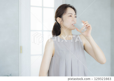 中年婦女在廚房喝水 129321663