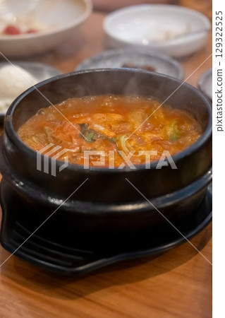 Kimchi Soup served in a bowl, with Korean side dishes served on the table Kimchi Soup served in a bowl, with Korean side dishes served on the table 129322525
