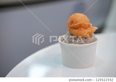 A cup of Gelato, Banana choc chip and tomato Ice-cream on the table with blur background. A cup of Gelato, Banana choc chip and tomato Ice-cream on the table with blur background. 129322542