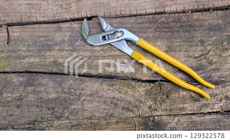 Plumber's adjustable wrench on wooden surface for home repair and maintenance. Pipe wrench, Swedish wrench. Horizontal banner. Copy space Plumber's adjustable wrench on wooden surface for home repair and maintenance. Pipe wrench, Swedish wrench. Horizontal banner. Copy space 129322578