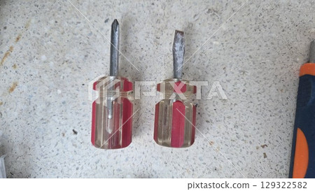 Variety of screwdrivers on textured surface for home repair and diy projects. Horizontal banner. Copy space 129322582