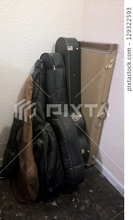 Collection of guitar cases in room corner Collection of guitar cases in room corner 129322593