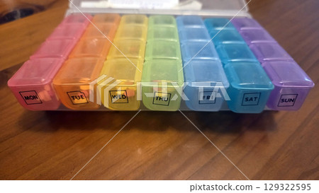 Colorful weekly pill organizer with seven compartments for daily medication management. Pill boxes 129322595