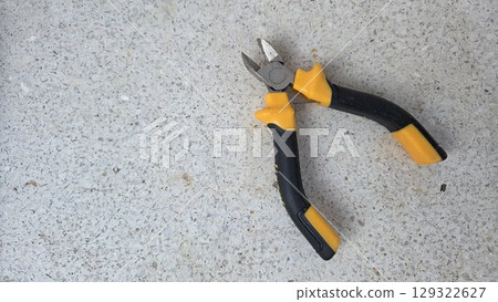 Diagonal pliers on concrete surface for diy tools and maintenance projects. Horizontal banner. Copy space. Wire cutters or diagonal cutting pliers Diagonal pliers on concrete surface for diy tools and maintenance projects. Horizontal banner. Copy space. Wire cutters or diagonal cutting pliers 129322627