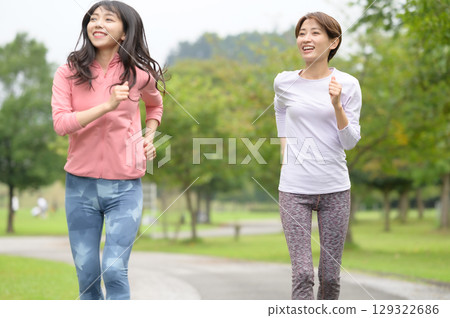 Two women jogging in the park Two women jogging in the park 129322686