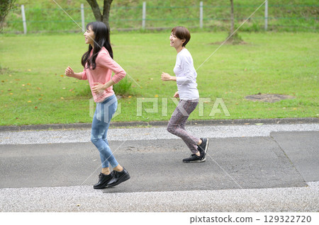 Two women jogging in the park Two women jogging in the park 129322720