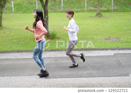 Two women jogging in the park Two women jogging in the park 129322721