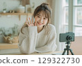 Young asian woman creating content for social media with her camera in bright room 129322730