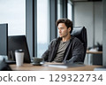 Young professional working at the office on his computer with a focused attitude 129322734