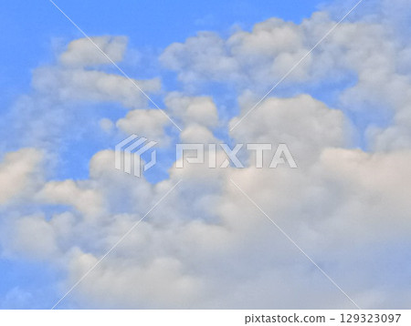 Fluffy clouds floating in the summer sky 129323097