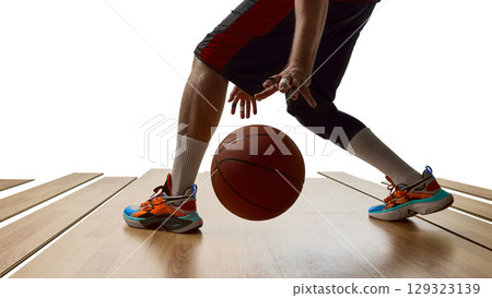 Basketball player in mid-dribble motion on wooden court with dynamic posture 129323139