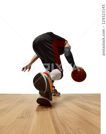 Low angle basketball player dribbling on court in bright sneakers Low angle basketball player dribbling on court in bright sneakers 129323145