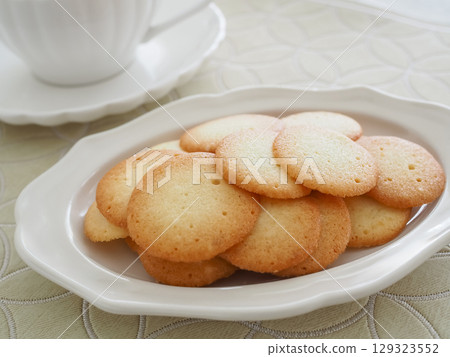 Homemade langue de chat cookies on a white plate Homemade langue de chat cookies on a white plate 129323552