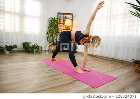 Mindful yoga practice in a serene indoor space with plants 129324071