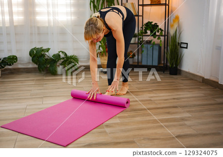 Practicing yoga in a serene indoor space with a vibrant mat 129324075