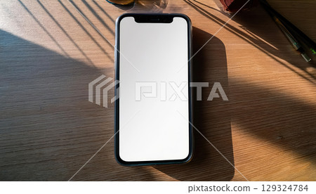 sleek smartphone with blank screen elegantly displayed on minimalist desk, capturing serene atmosphere 129324784