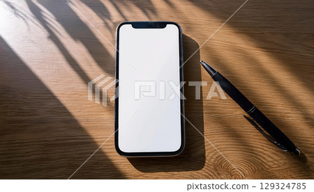sleek smartphone with blank screen elegantly displayed minimalist desk, accompanied by pen, creates soft and modern atmosphere 129324785
