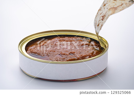 Opening a can of meat with a gold cap and a white background and hard to open. Opening a can of meat with a gold cap and a white background and hard to open. 129325066