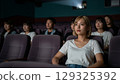 年輕女子在電影院看電影 129325392