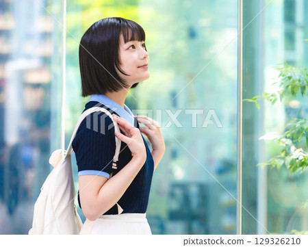 Female student looking up by the window 129326210
