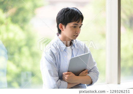 A male student with his head down in thought 129326251