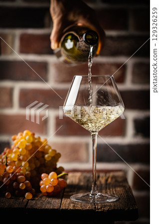 Pouring white wine 129326259