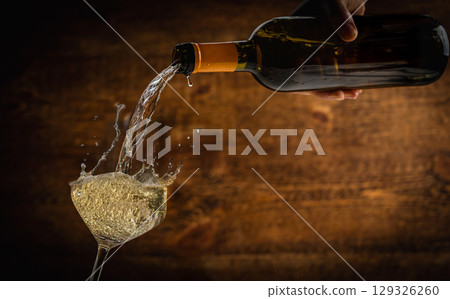 White sparkling wine being poured into a glass White sparkling wine being poured into a glass 129326260