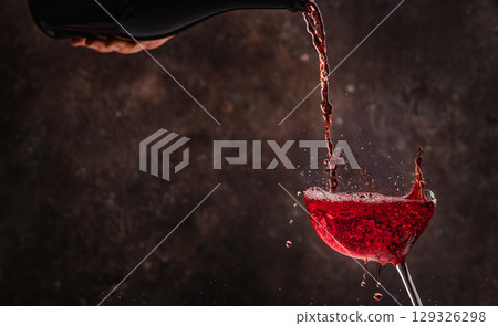 Red wine being poured into a glas 129326298