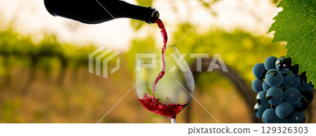 Wine glass with pouring red wine 129326303