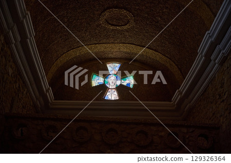 Stained Glass Cross with Religious Symbolism in Stone Interior 129326364