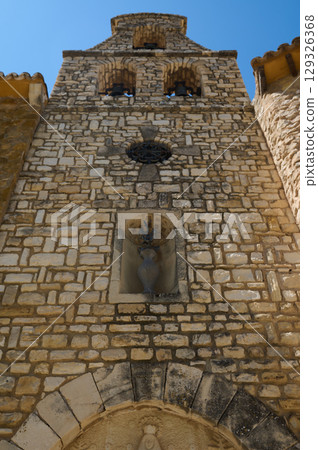 Historic Stone Bell Tower with Religious Ornament in Clear Daylight 129326368