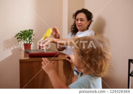 Mother and Child Bonding While Playing with a Yellow Pet Bird at Home 129326369