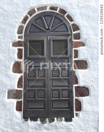 Elegant rustic wooden window decorating whitewashed wall 129326842