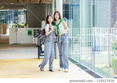 A female college student walking with friends on campus 129327416