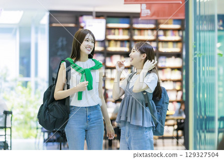 一名女大學生與朋友一起爬校園樓梯 一名女大學生與朋友一起爬校園樓梯 129327504