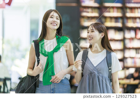 A female college student climbing the stairs on campus with her friends 129327523