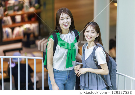 一名女大學生與朋友一起爬校園樓梯 一名女大學生與朋友一起爬校園樓梯 129327528