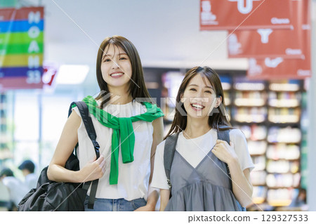 A female college student climbing the stairs on campus with her friends A female college student climbing the stairs on campus with her friends 129327533