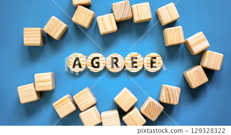 Agree symbol. Concept word Agree on beautiful wooden circles. Beautiful blue table blue background. Beautiful wooden cubes. Business agree concept. Copy space. 129328322